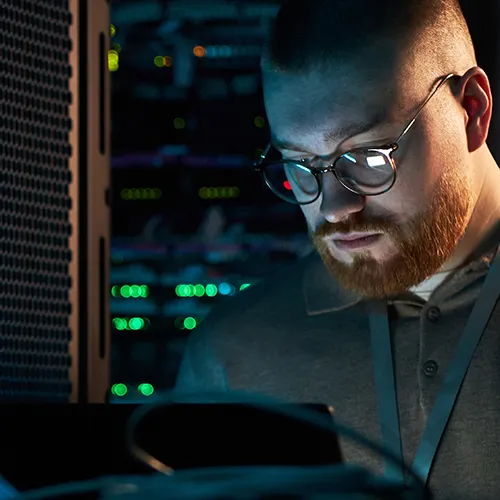 Techniker mit Headset arbeitet am Computer im Serverraum